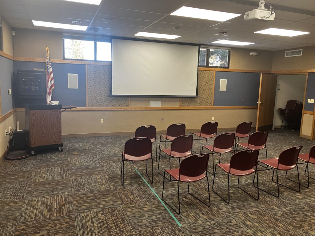 An inviting meeting room with chairs for 48 people, and AV equipment including a projector screen.