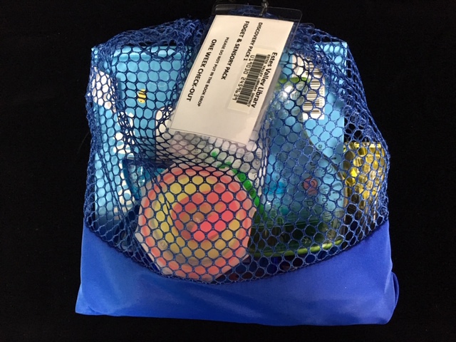 A mesh bag "Discovery Pack" full of toys for young children to check out from the library.