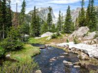A flowing stream through granite mountains in the daylight.