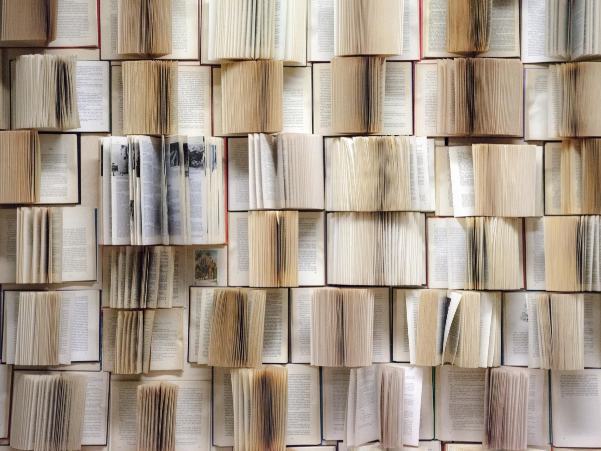 A collage of open books, showing pages and writing from a zoomed out perspective.