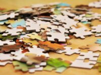 A recurring pattern of jigsaw puzzle pieces in a variety of colors.